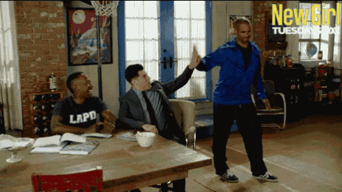 a man wearing a lapd shirt gives a high five to another man