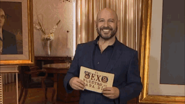 a man in a suit is holding a sign that says el sexo