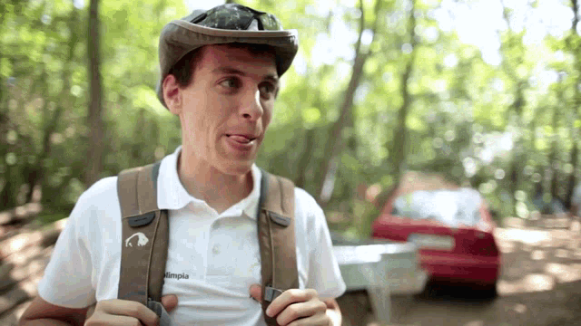 a man wearing a helmet and a backpack with olympia written on his shirt