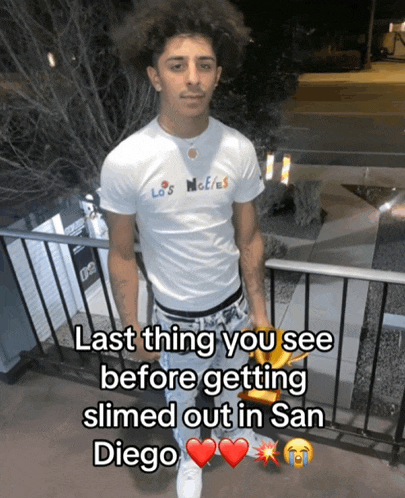 a young man in a los angeles t-shirt holds a bag of french fries