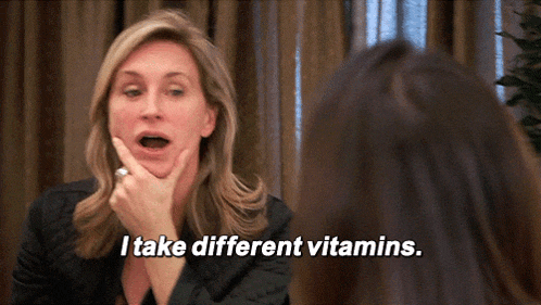 a woman says " i take different vitamins " in front of a mirror