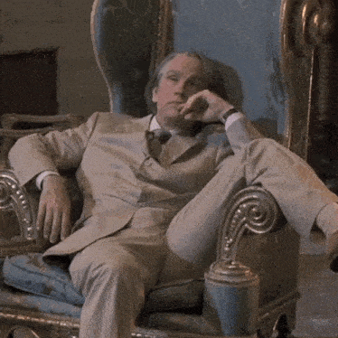 a man in a suit and tie is sitting in a chair