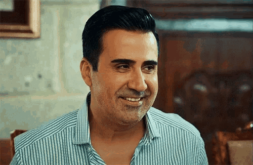 a man wearing a blue and white striped shirt smiles