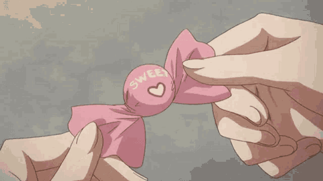 a person is holding a piece of pink paper with a red heart in it .