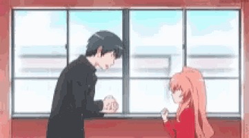 a man and a girl are standing next to each other in front of a window in a room .