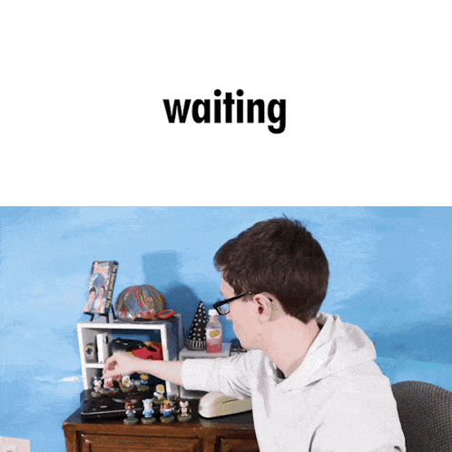 a man sitting at a desk with the word waiting on the bottom