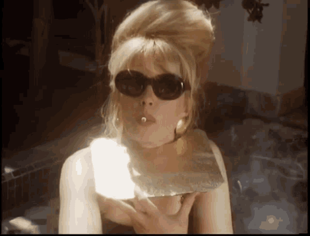 a woman wearing sunglasses is holding a piece of gold