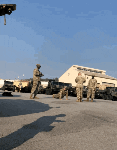 a man in a military uniform is doing push ups in front of a building