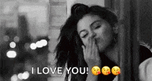a black and white photo of a woman blowing a kiss and saying i love you .