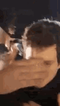 a man is getting his hair cut with a trimmer .
