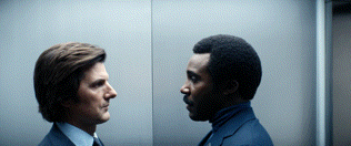 two men in suits are looking at each other