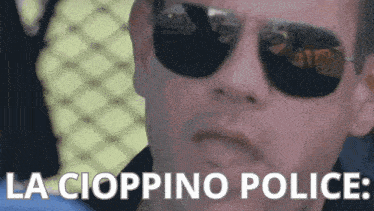a man wearing sunglasses says " la cioppino police " in white letters