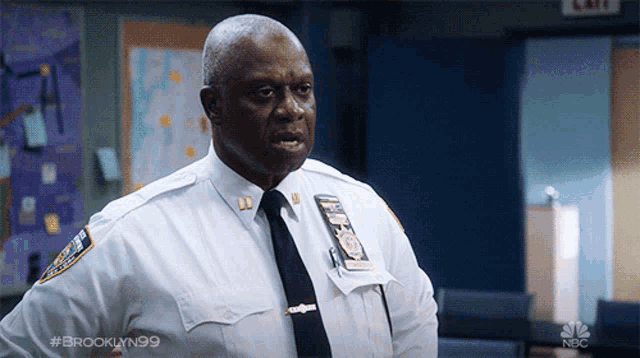 a police officer from brooklyn 99 is standing in a room