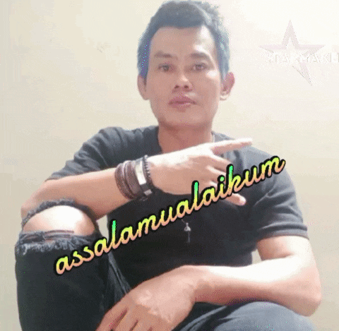 a man wearing a black shirt with the word assalamualaikum on it