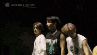 a group of young men are dancing on a stage with the words tomorrow x together written above them
