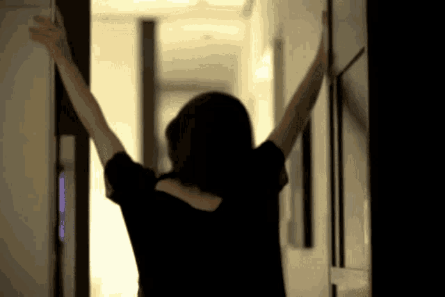 a person with their arms outstretched standing in a hallway