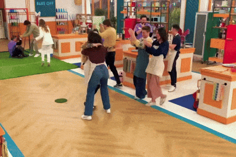 a group of people dancing in a kitchen with a sign that says bake off