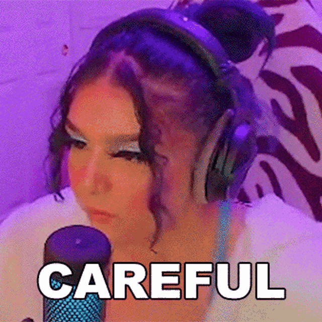 a woman wearing headphones is sitting in front of a microphone and the word careful is on the bottom