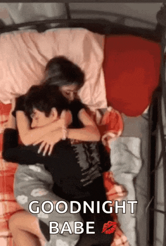 a man and a woman are laying in bed hugging each other .