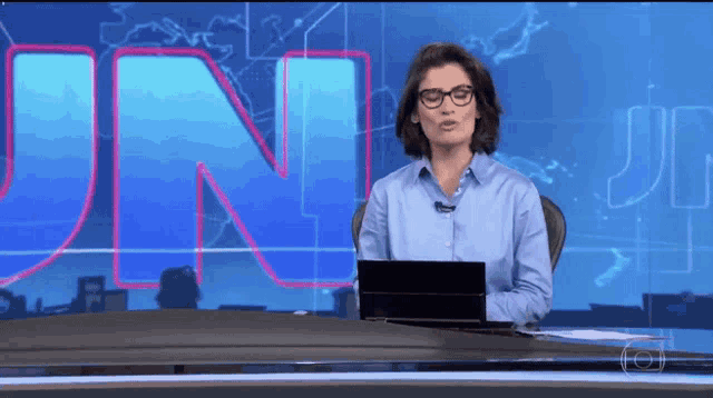 a woman is sitting at a desk in front of a large letter n