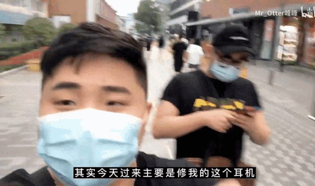 a man wearing a mask talks to another man