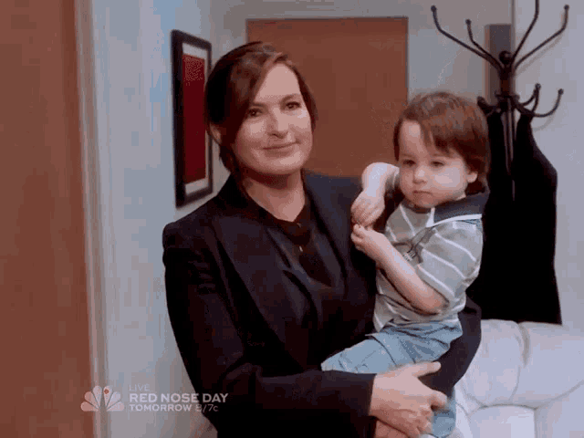 a woman is holding a little boy in her arms with the words red nose day tomorrow on the bottom