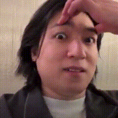 a woman is making a funny face while touching her forehead .