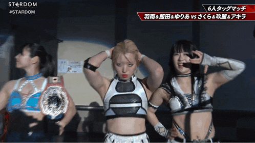 three female wrestlers are posing for a photo in front of a sign that says stardom on it