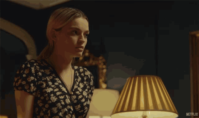 a woman is standing in front of a lamp with the words oh my god written on it