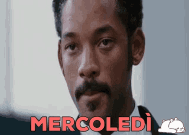 a close up of a man 's face with the word mercoledì in red letters