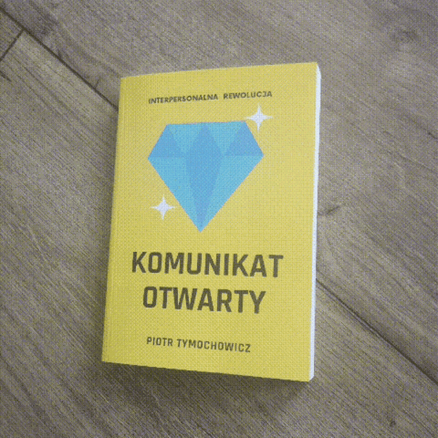 a yellow book with a blue diamond on the cover is titled komunikat otwarty