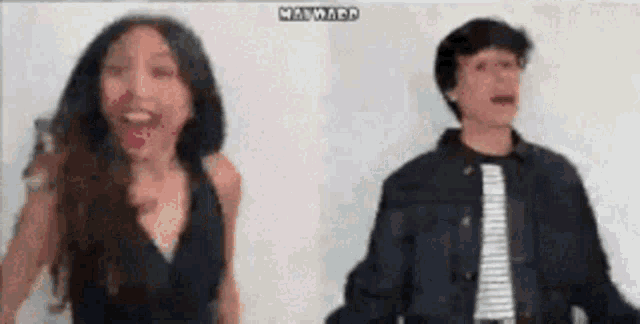 a man and a woman are standing next to each other .