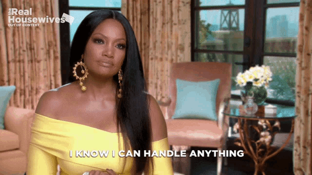 a woman in a yellow dress says " i know i can handle anything " in a living room