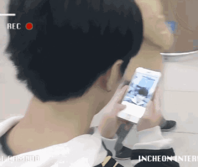 a person holding a cell phone with the word rec on the top