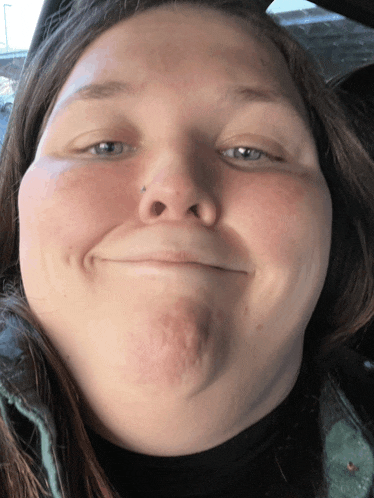 a woman with a nose piercing makes a face