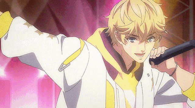 a blonde anime boy is holding a microphone in his hand and singing into it .
