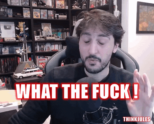a man sitting in front of a microphone with the words what the fuck