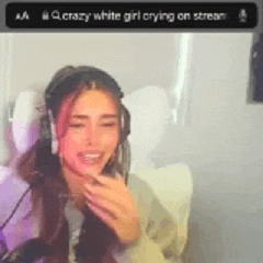 a woman is crying on a stream while wearing headphones and smiling .