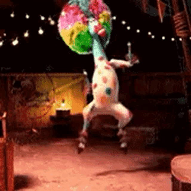 a clown is dancing in a dark room