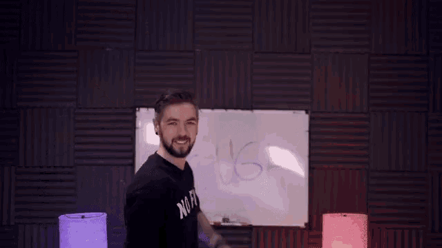 a man is pointing at a whiteboard that says laugh