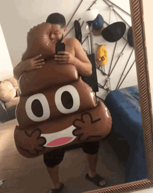 a man in a poop costume takes a picture of himself in the mirror