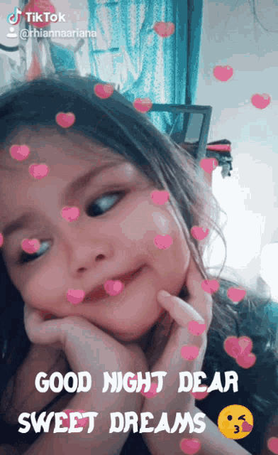 a little girl with pink hearts around her face and the words good night dear sweet dreams