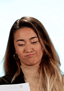 a woman making a funny face while holding a piece of paper with the word mexico on it
