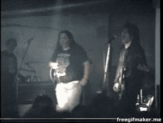 a man in a black shirt with a skull on it stands next to another man