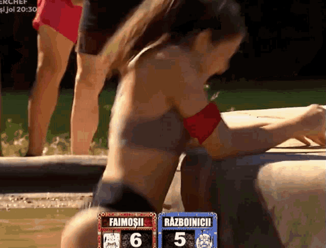 a woman in a bikini sits next to a scoreboard that says faimosii 6 razboinii 5
