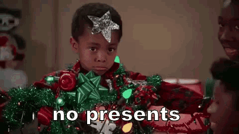a young boy with a star on his head is holding christmas lights and tinsel .