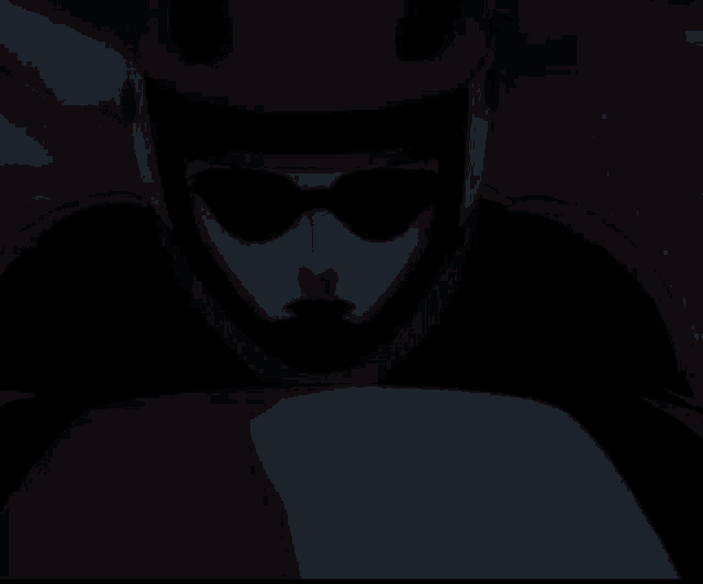 a man in a red helmet and sunglasses is looking at something
