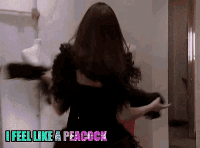 a woman in a black dress is dancing with the words " i feel like a peacock " below her