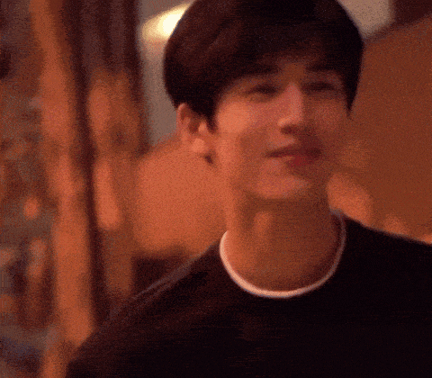 a close up of a young man 's face wearing a black shirt and smiling .