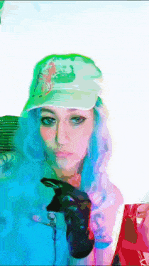 a woman with blue hair wearing a green hat and black gloves holding a cell phone